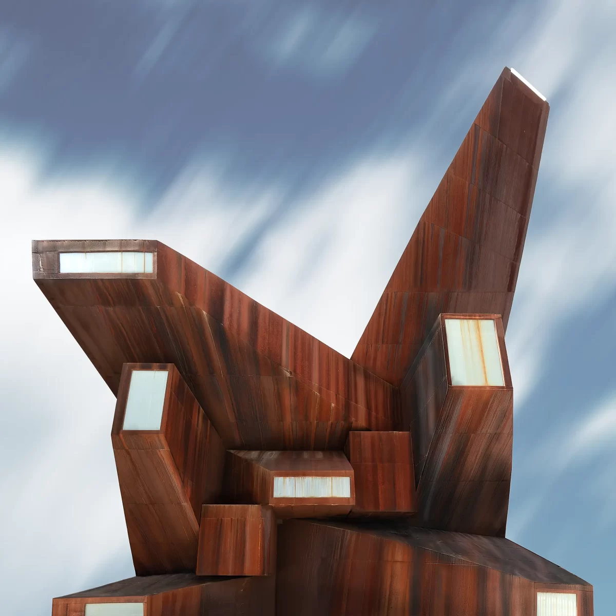 The backside of St Monica's Church in Madrid with its characteristic corten steel leaning towers and skylights by VICENS+RAMOS architects, captured by architectural photographer Ondrej Hromadko.