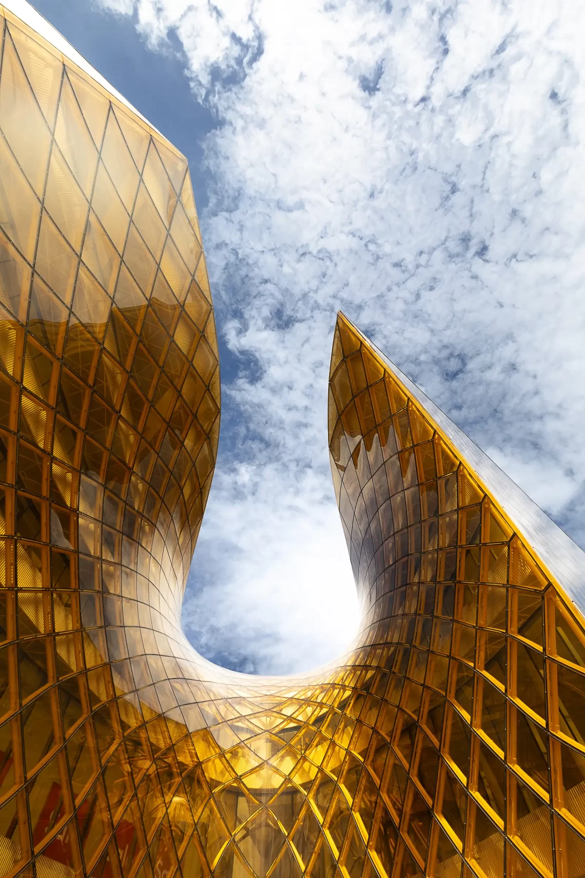 Detailní fotografie fluidní architektury nákupního centra Emporia v Malmö s zaměřením na vlnový výkus do skleněného opláštění budovy.