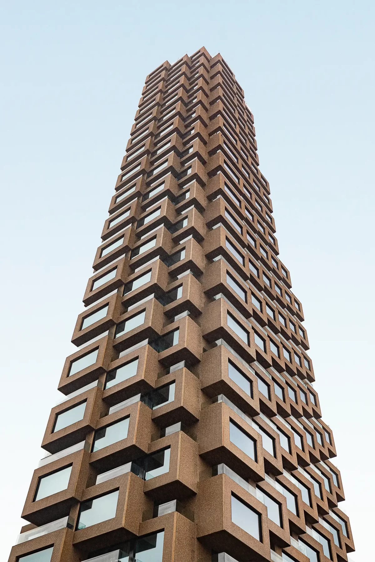 Ein Blick von unten auf den Wolkenkratzer Norra Tornen in Stockholm von OMA Architects, der die rhythmische Struktur der Fassade hervorhebt; fotografiert vom Architekturfotografen Ondrej Hromadko.