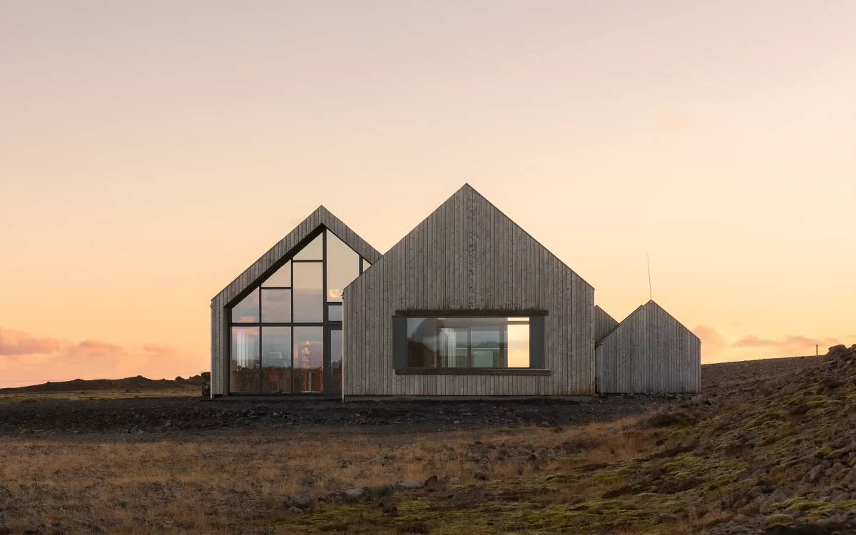 Minimalistická dřevostavba s velkými skleněnými plochami zasazená do islandské krajiny – profesionální fotografie architektury od Ondřeje Hromádka.