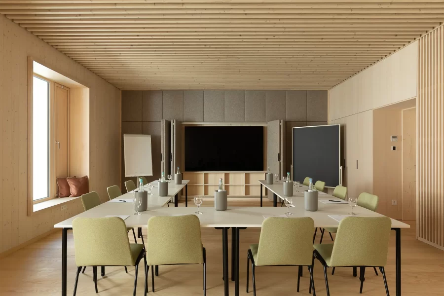 Meetingraum im Hotel Krone Oettingen mit U-Form-Bestuhlung, Präsentationsscreen, Flipchart, Holzlamellendecke und großzügigem Fenster.