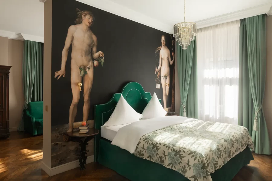 Schlafzimmer der Lisa-Tetzner-Junior-Suite im Schlossturm des Schlosshotels Althörnitz mit grünem Polsterbett und großformatigem Adam-und-Eva-Gemälde.