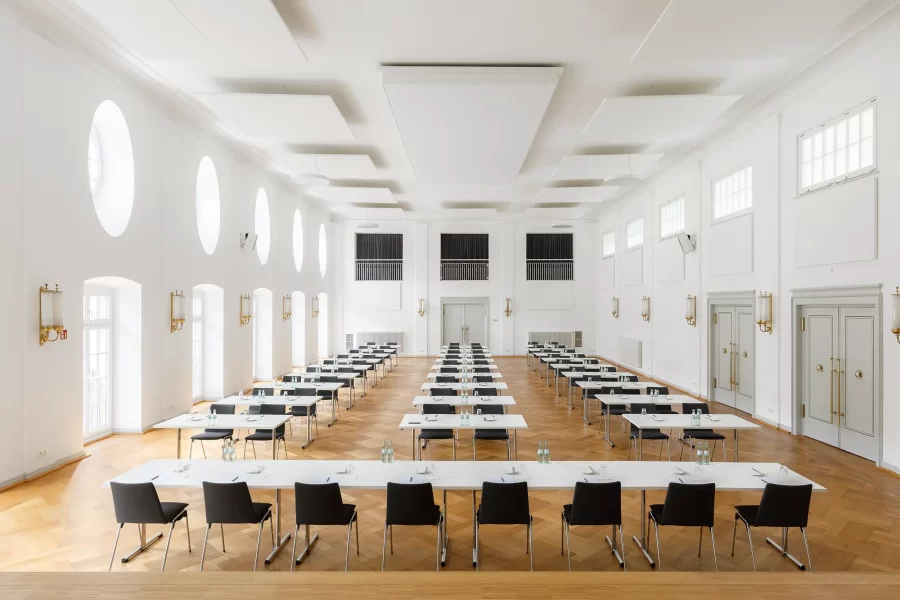 Konferenzbestuhlung im Kursaal Bad Bertrich mit klarer Reihenanordnung, Bühne und großzügigem Tageslichtraum.