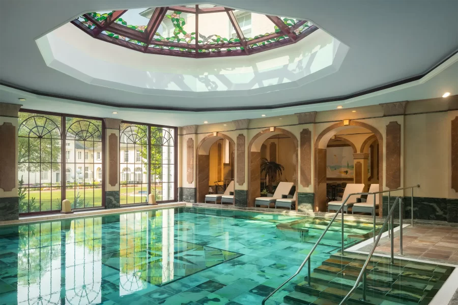 Innenpool im Wellnessbereich des Hotels Fürstenhof in Bad Bertrich mit historischer Architektur und natürlichem Tageslicht.