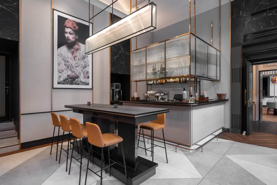 A hospitality photo of the elegant grey-toned hotel bar and orange bar chairs in Radisson Blu Prague, Czech Republic