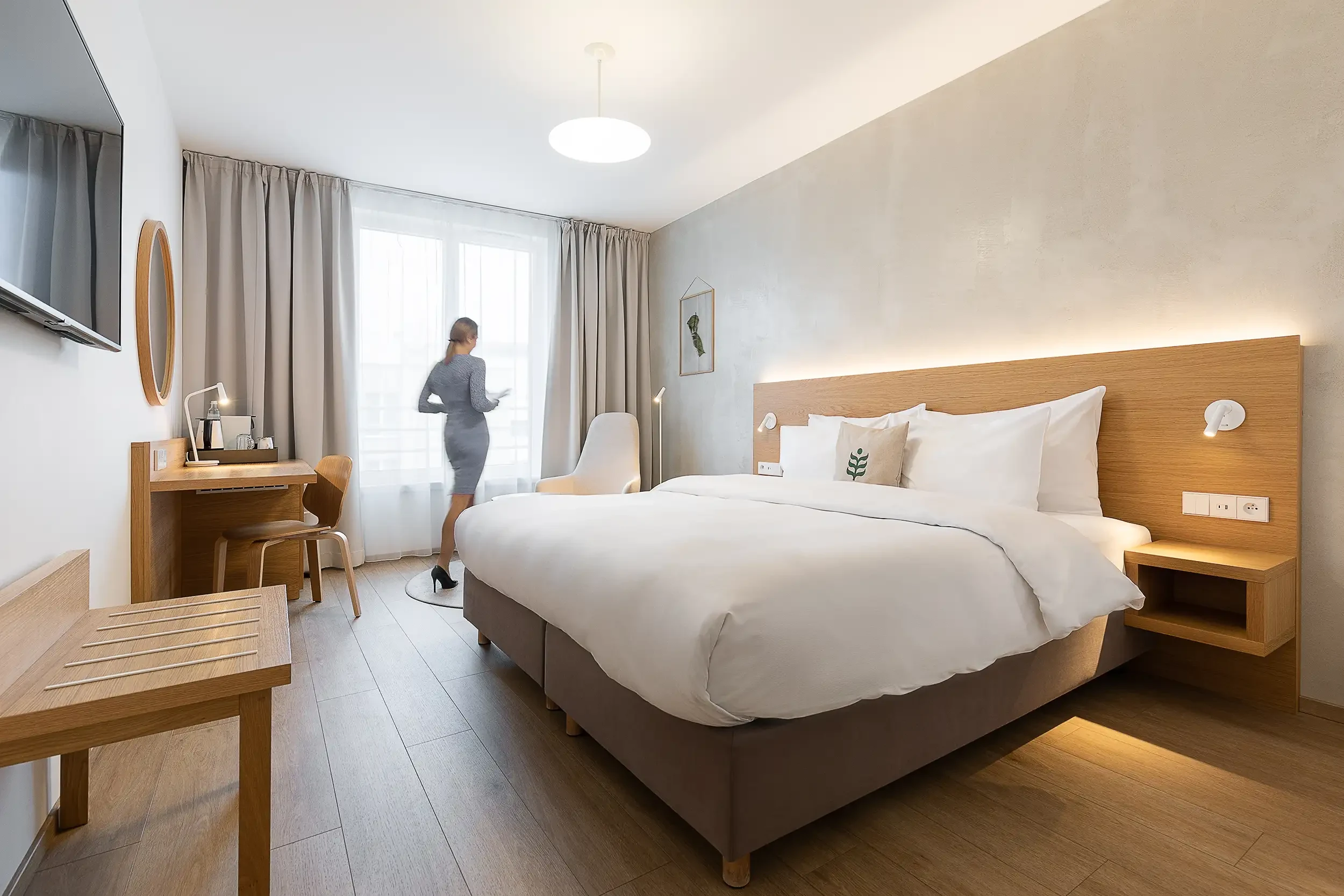 Botanique Executive King Zimmer mit Kingsize-Bett, Arbeitsbereich und unscharfem Gast in Bewegung am Fenster.