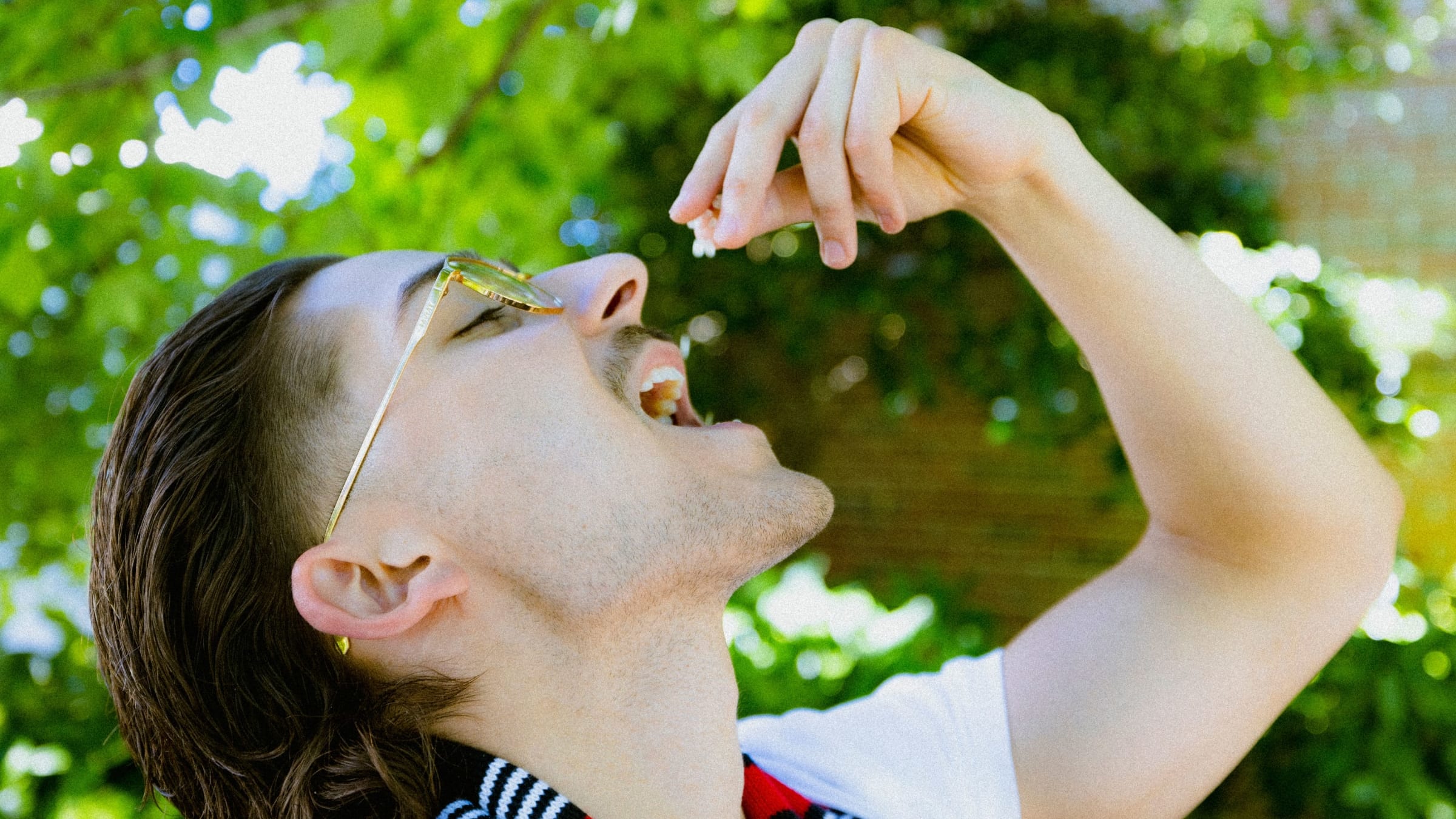 Side profile of man dropping mastic gum into his mouth