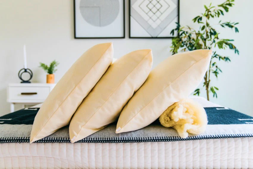 Three pillows from The Woolshire stacked next to each other