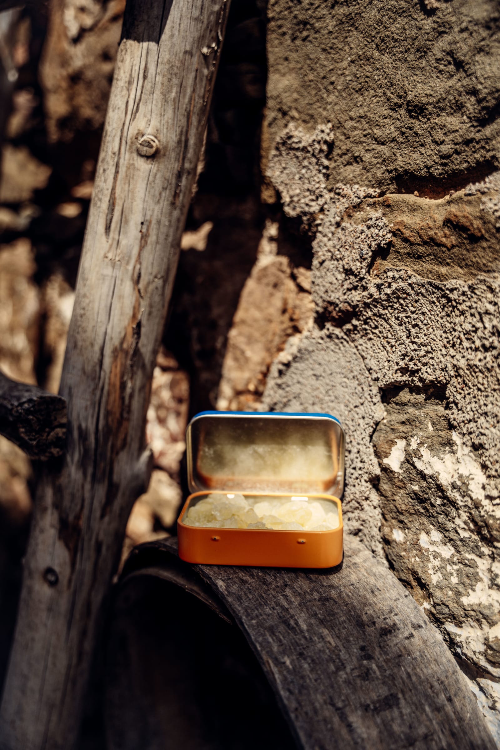 Tin of Greco Gum mastic nuggets in half sunlight