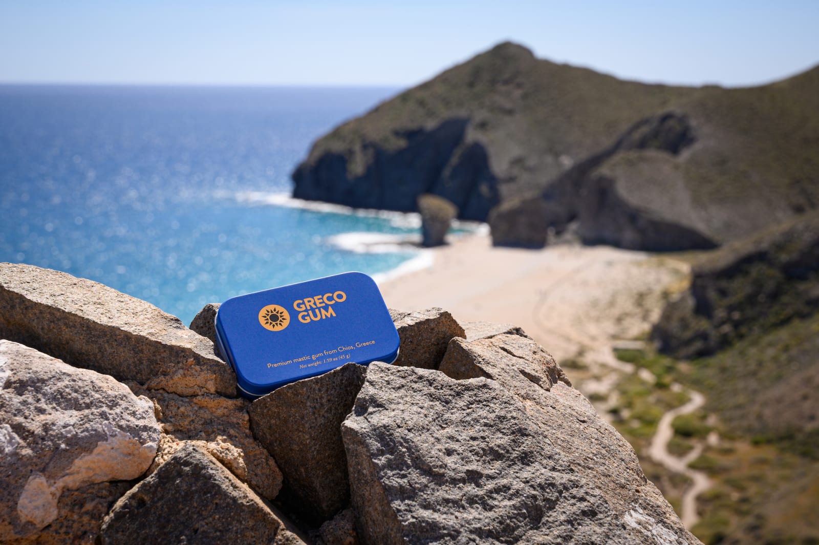 A tin of Greco Gum mastic gum perched atop a beach on Chios, Greece
