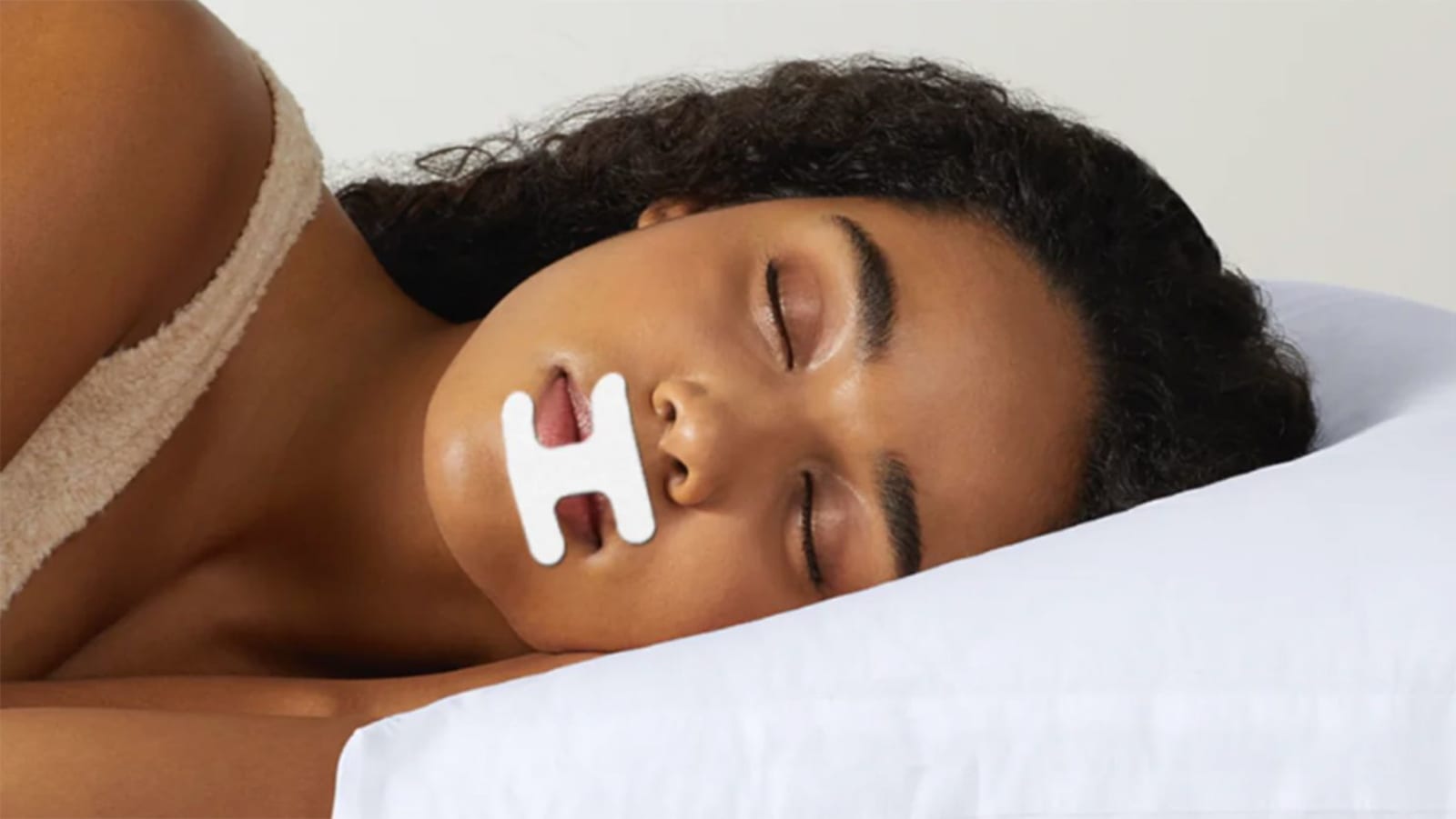 A woman sleeps with mouth tape to encourage nasal breathing