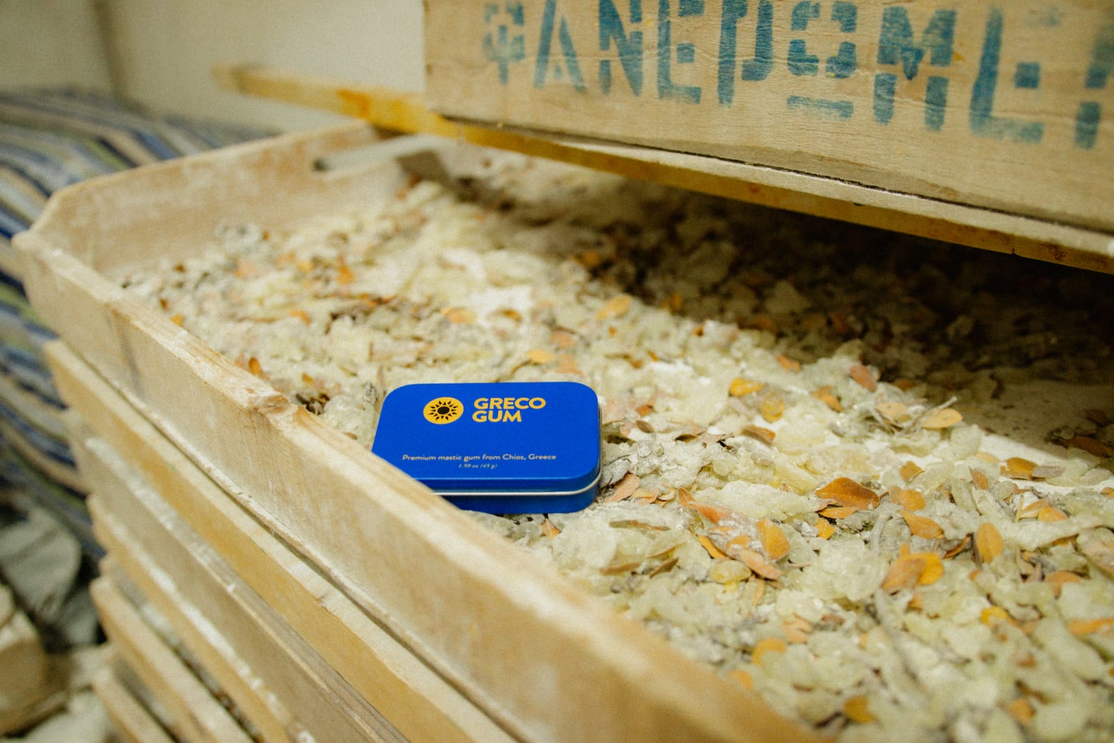 Greco Gum tin inside of a crate filled with mastic resin