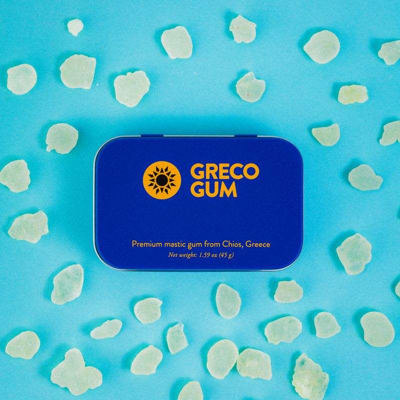 A tin of Greco Gum surrounded by mastic nuggets