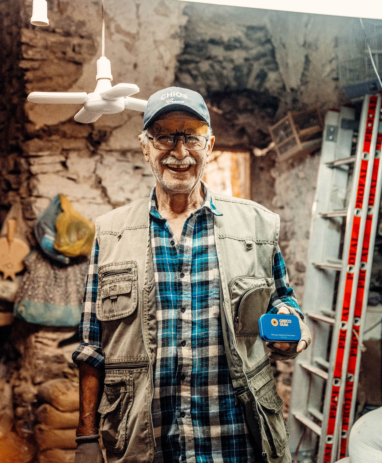 Man holding Greco Gum tin, smiling and laughing