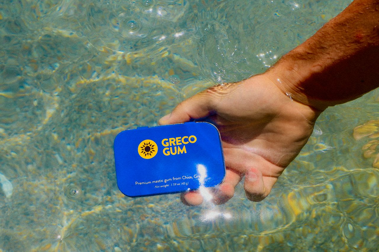 A blue tin of mastic gum held underwater with light glistening off it