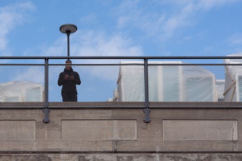 A man standing in front of a lamppost