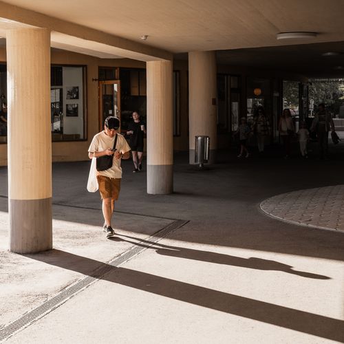 A man looking at his phone while walking