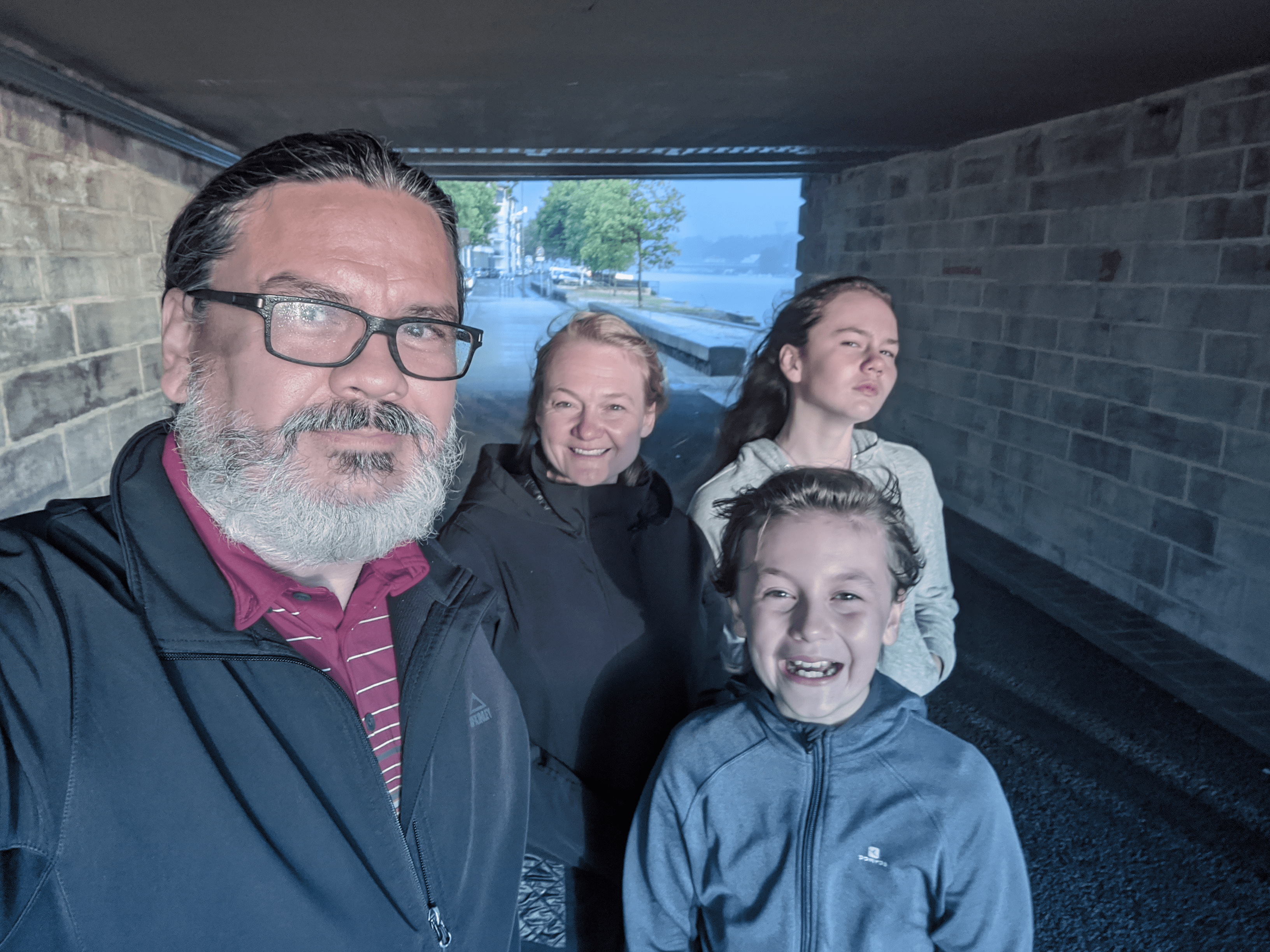 The Cookes are standing under a brudge while a rainshower drenches the city.