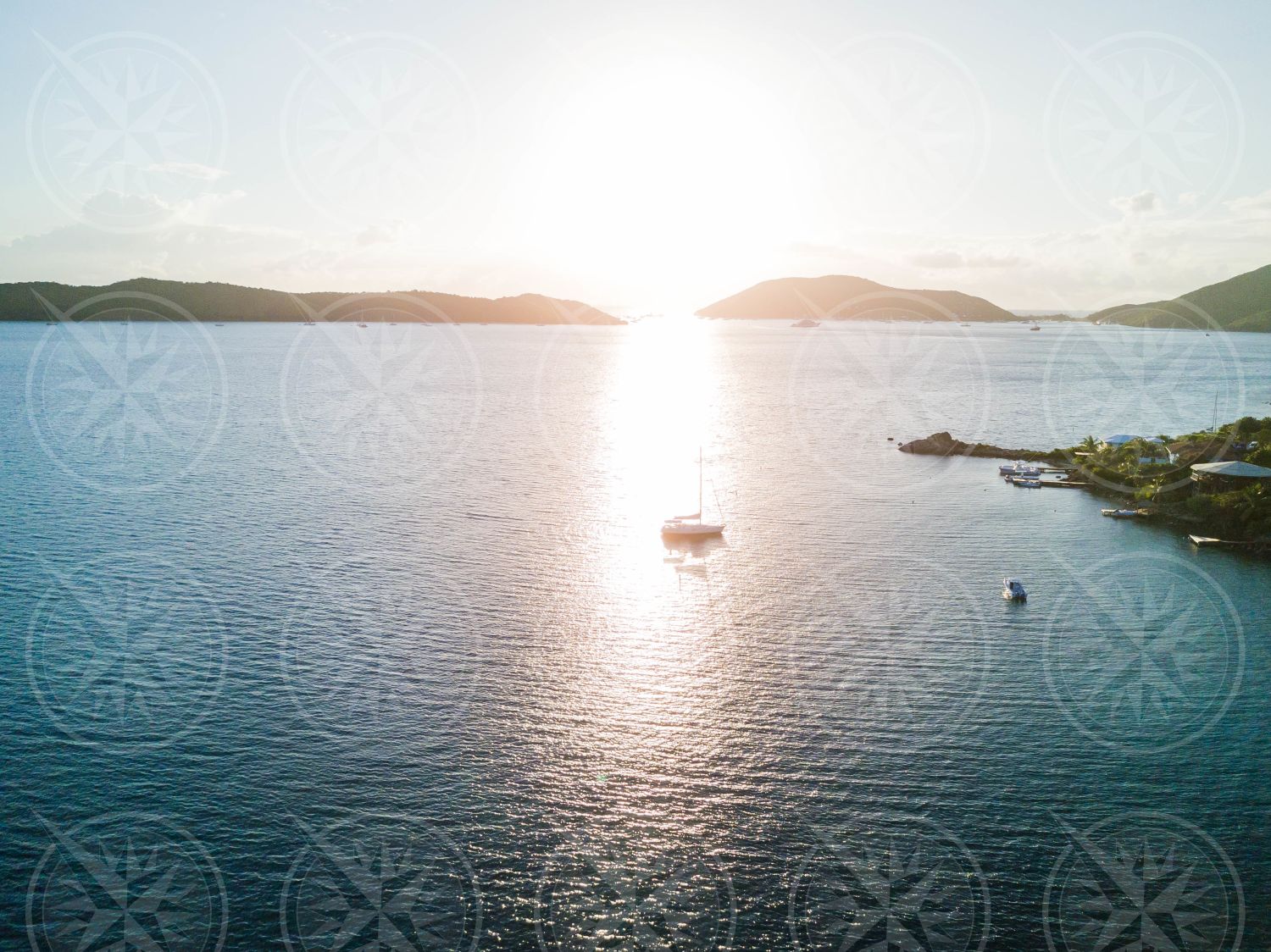 Yacht at anchor at sunset from drone