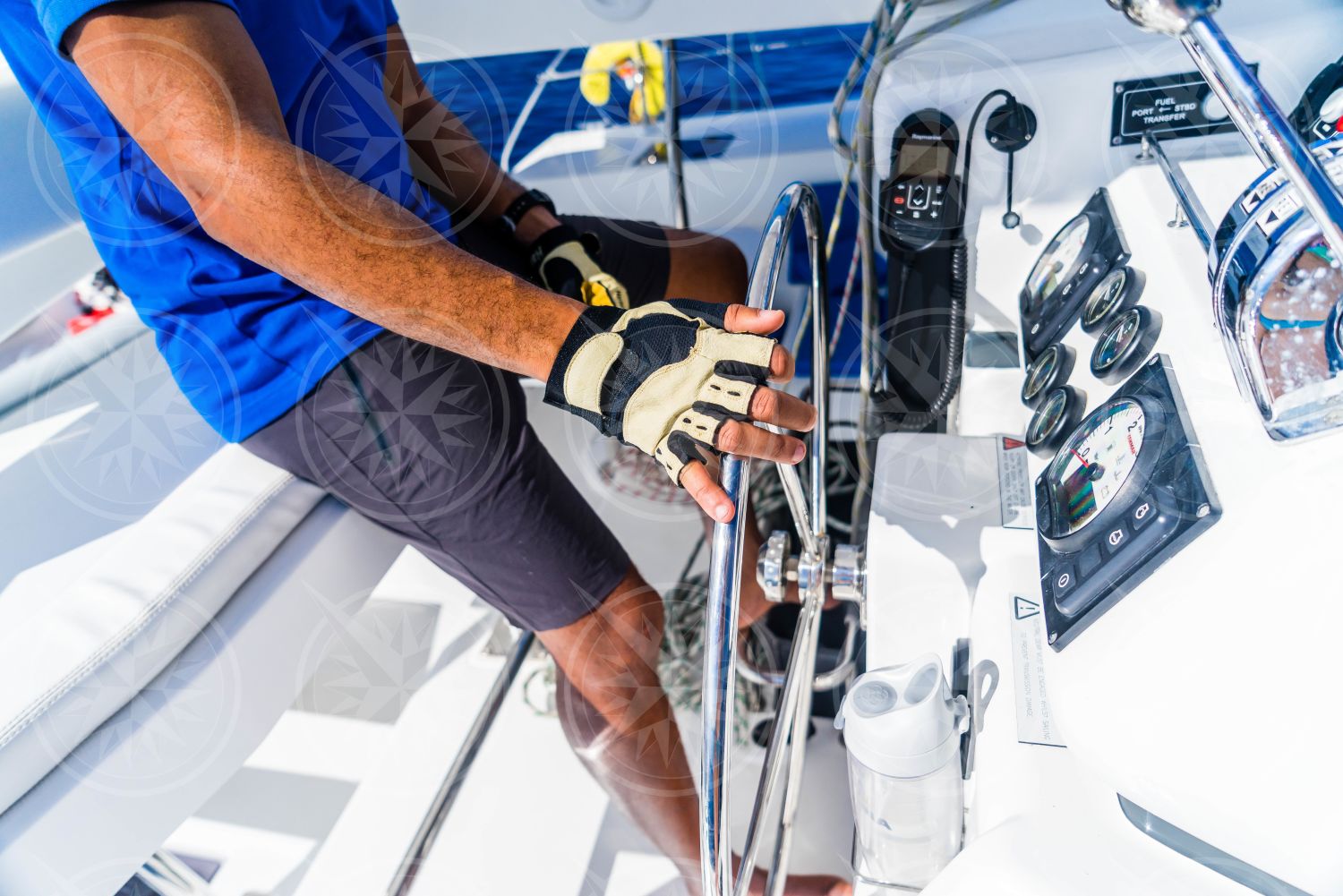 Detail of gloved hand on wheel at the helm of a sailboat