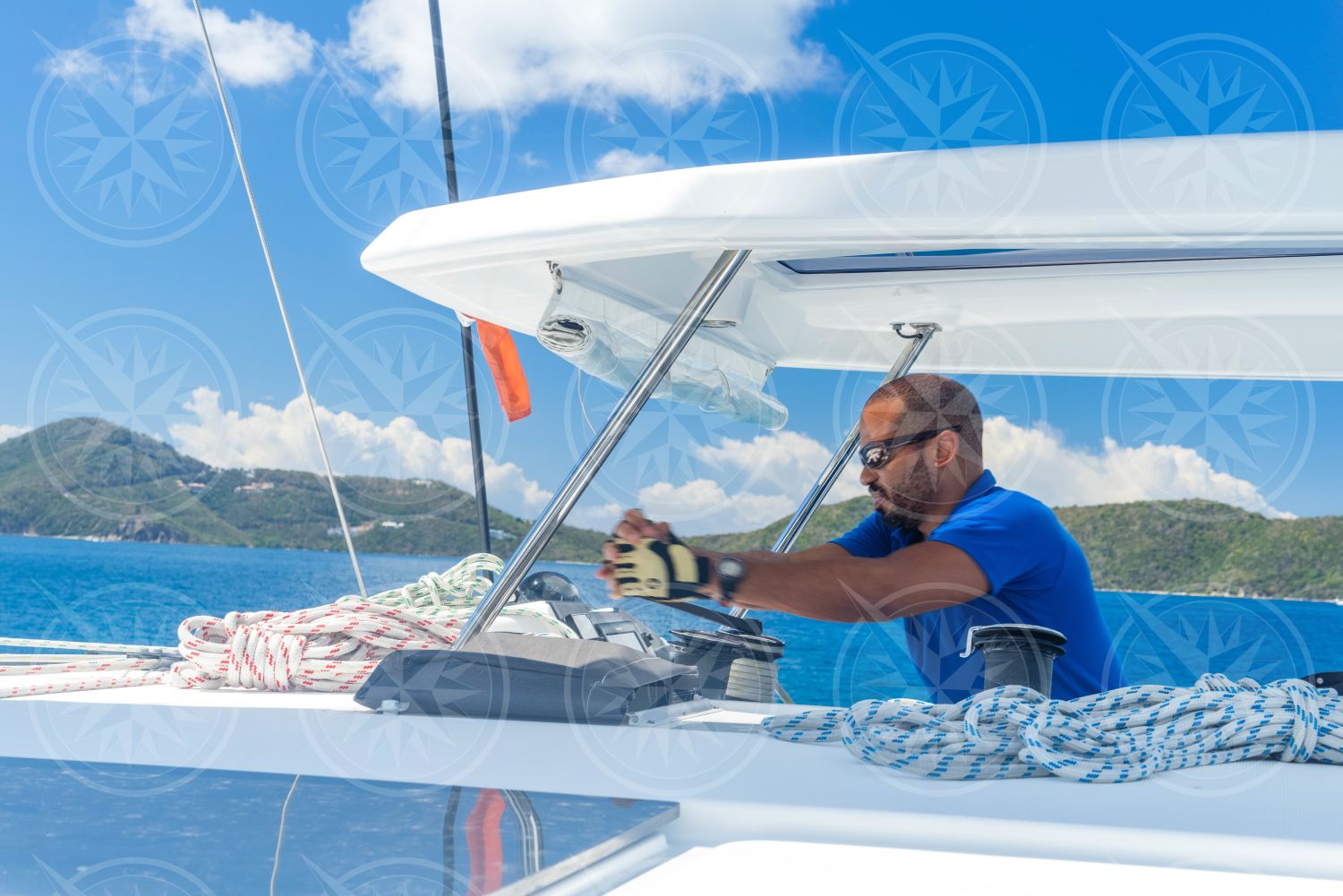 Man grinding winch sailing on catamaran