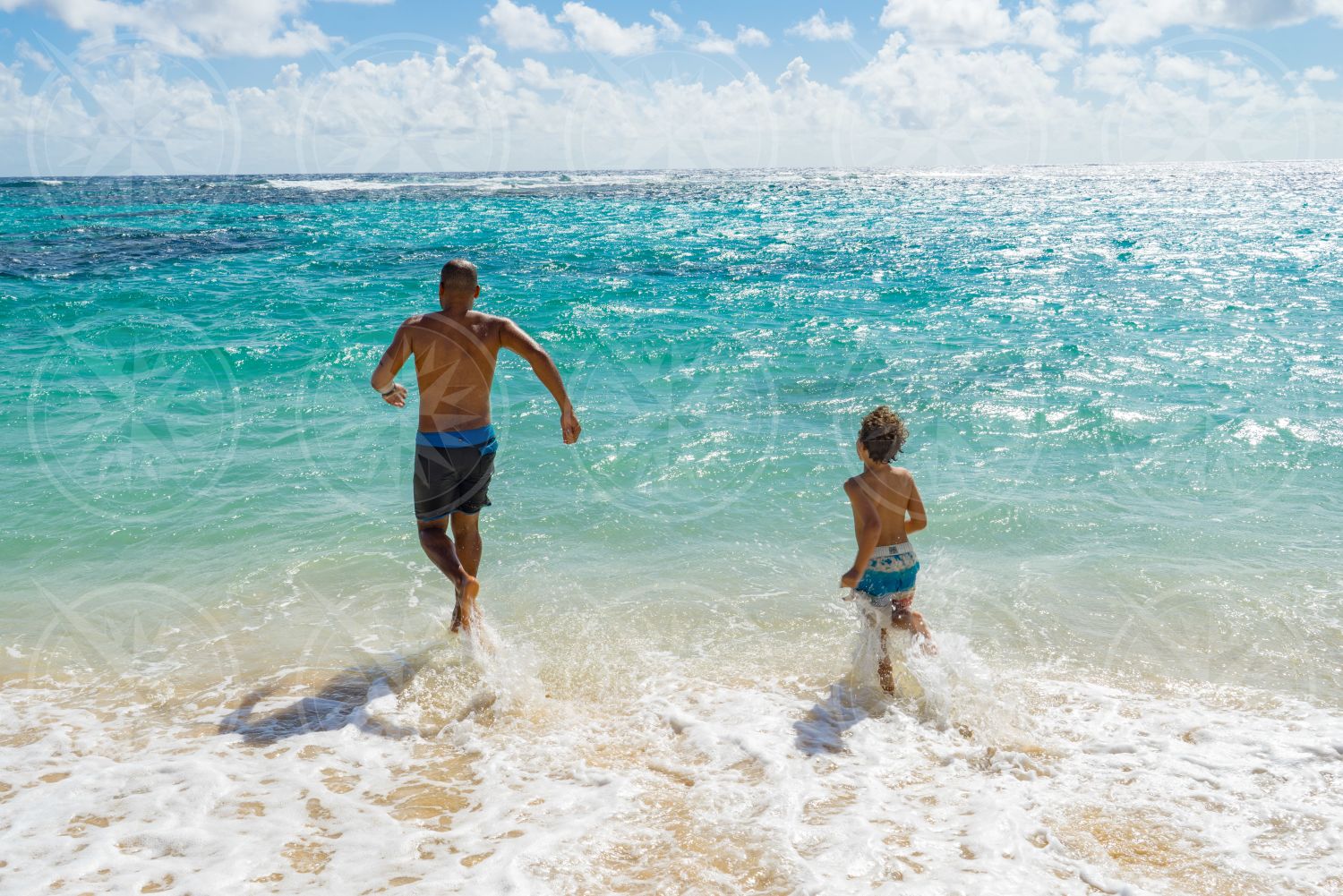 Man and boy running into the water