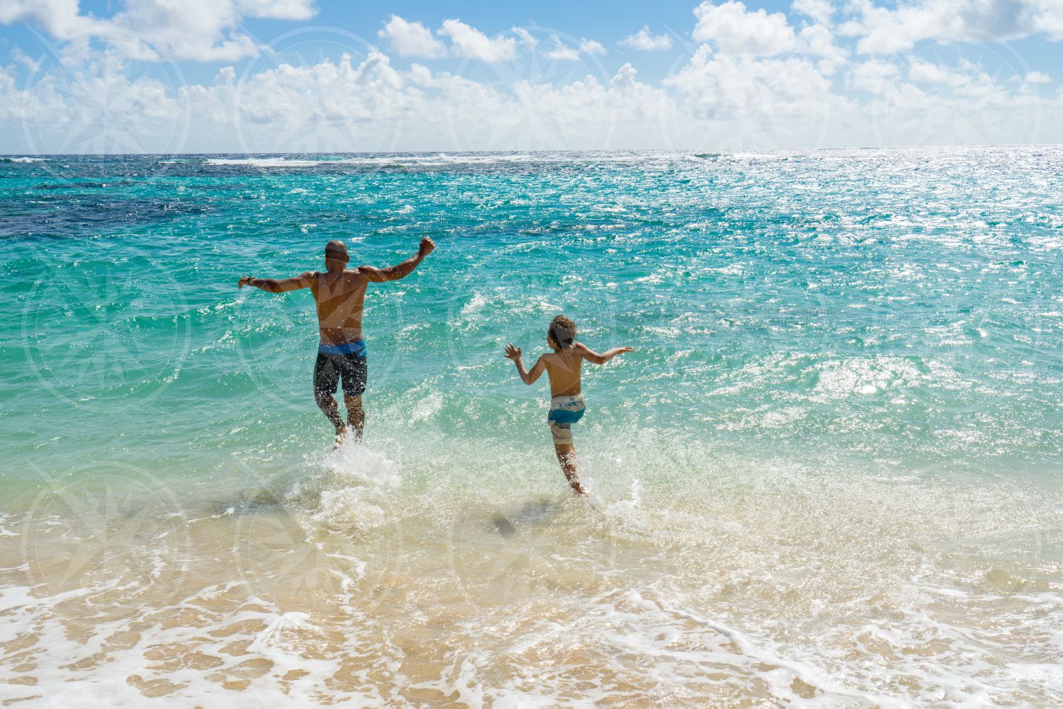 Man and boy running into the water