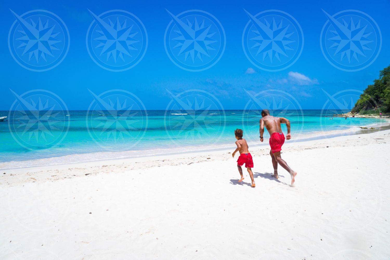 Boy and adult running on Long Bay Beach