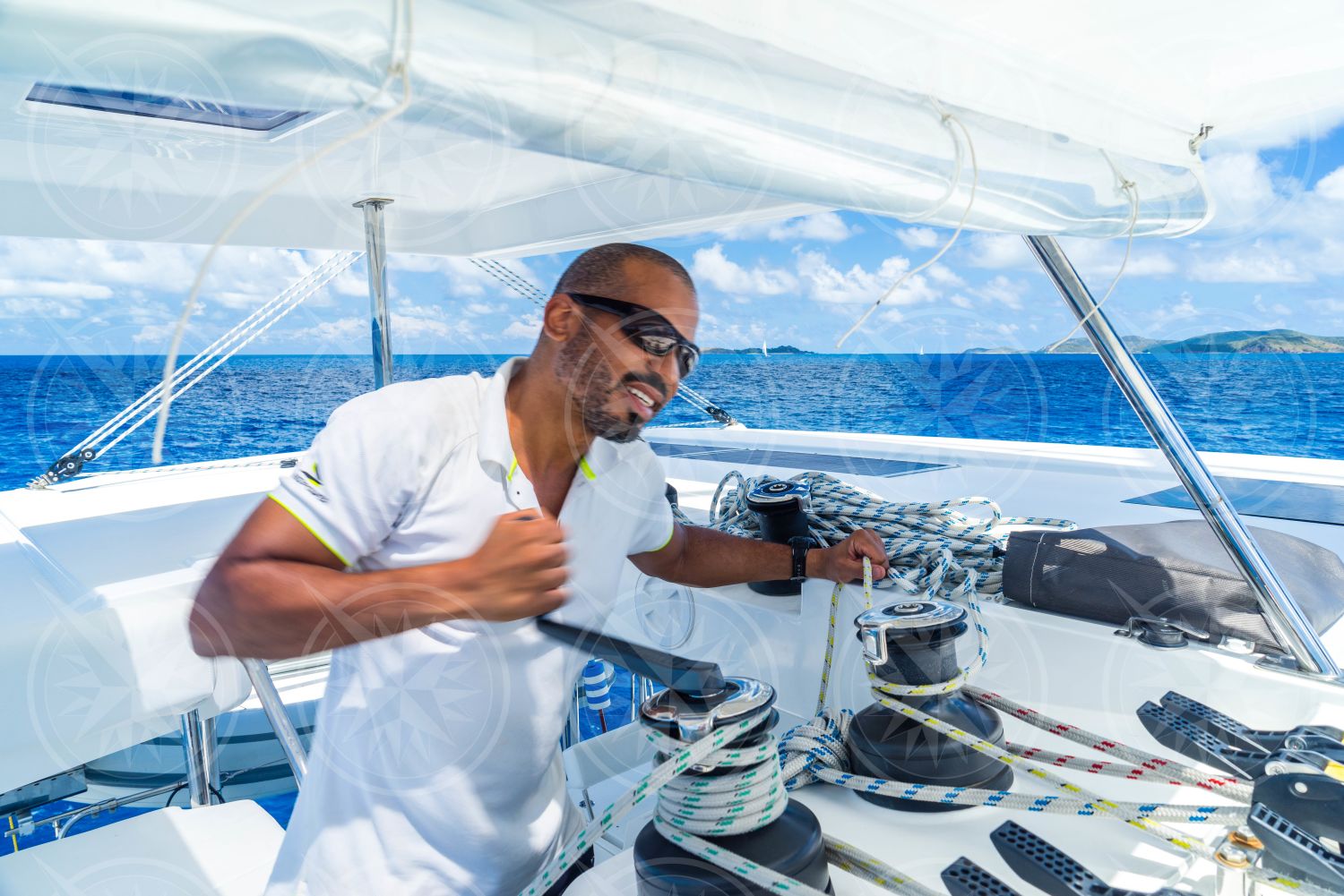 Man grinding winch on sailboat