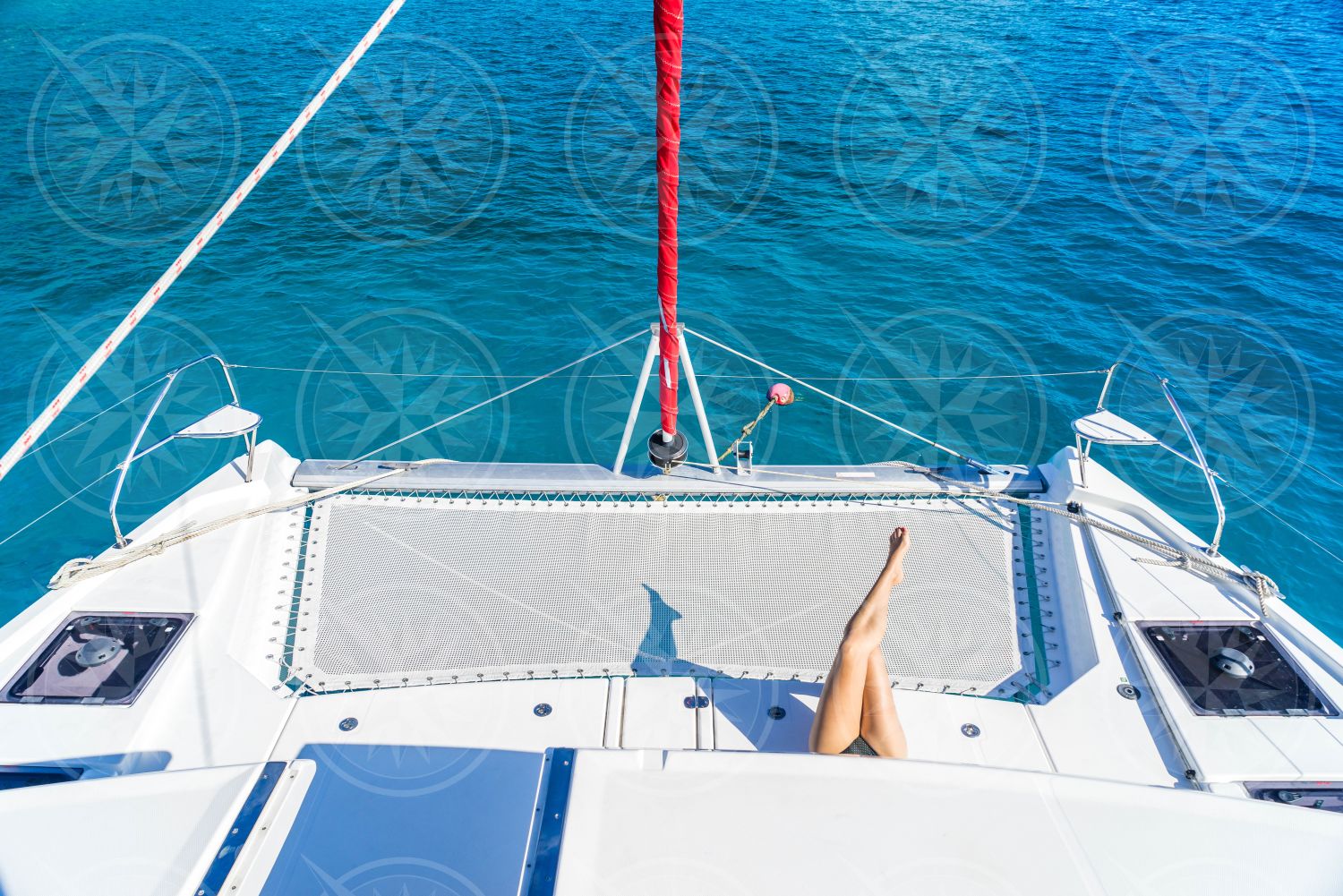 Woman laying near bow of catamaran from above