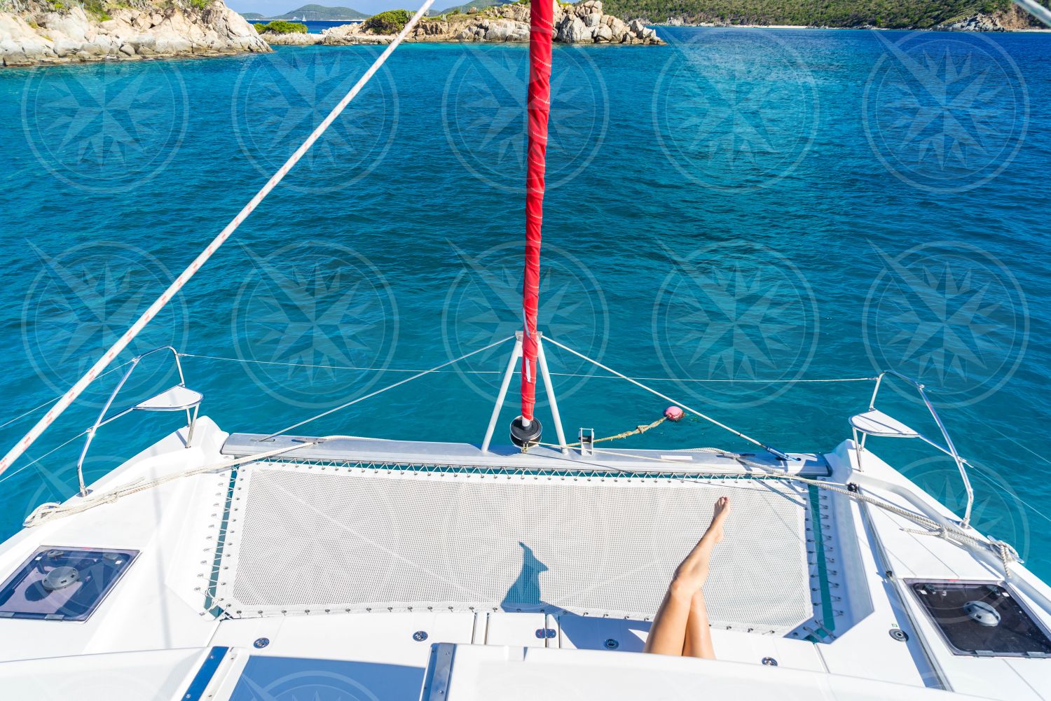 Woman laying near bow of catamaran from above