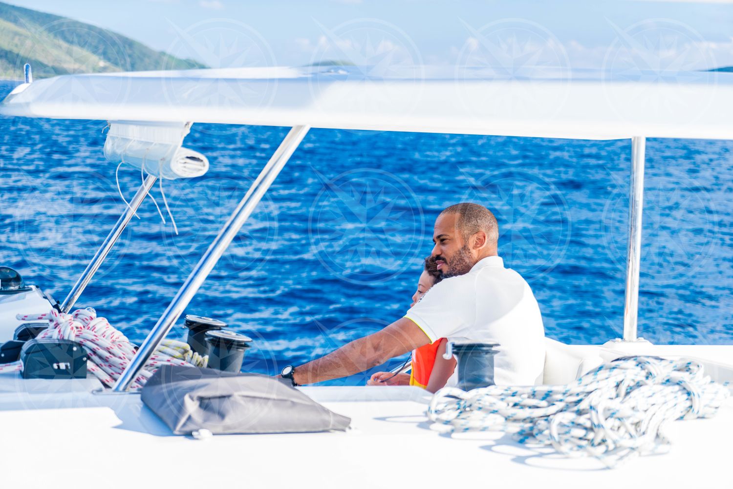 Man and boy at the helm of sailboat