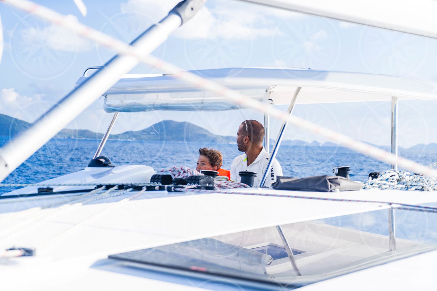 Man and boy at the helm of sailboat