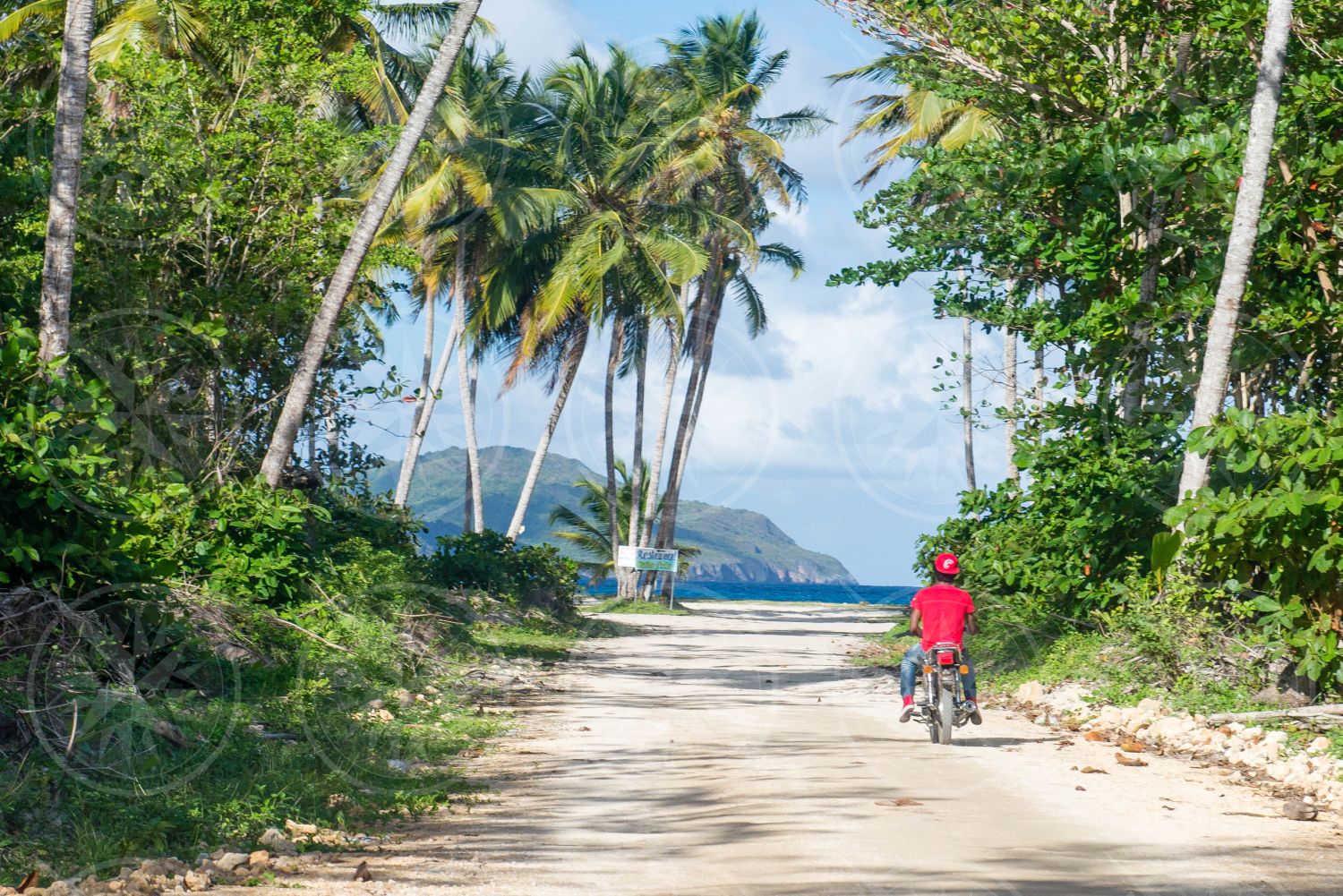 Man riding moto down dirt road