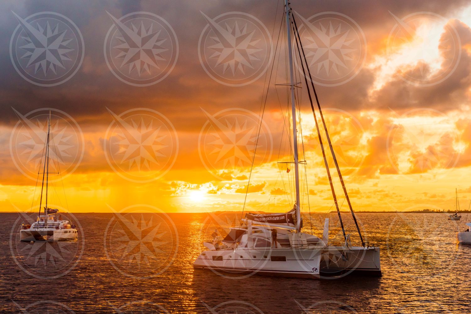 Sunset behind sailboats at sea