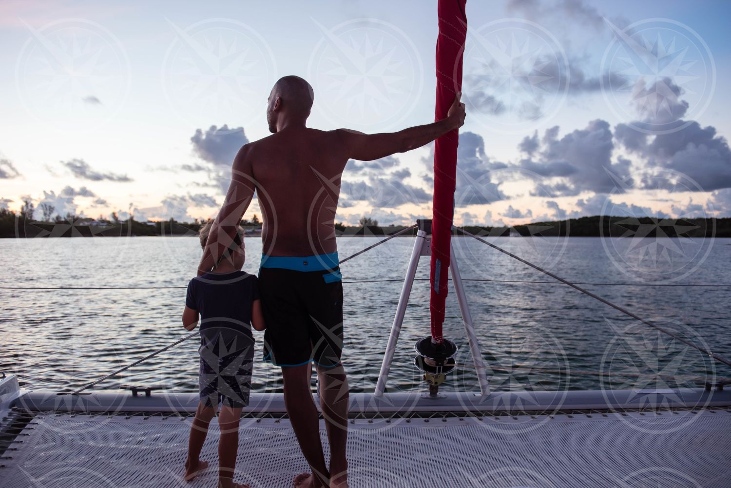 Man and boy on sailboat at sunset