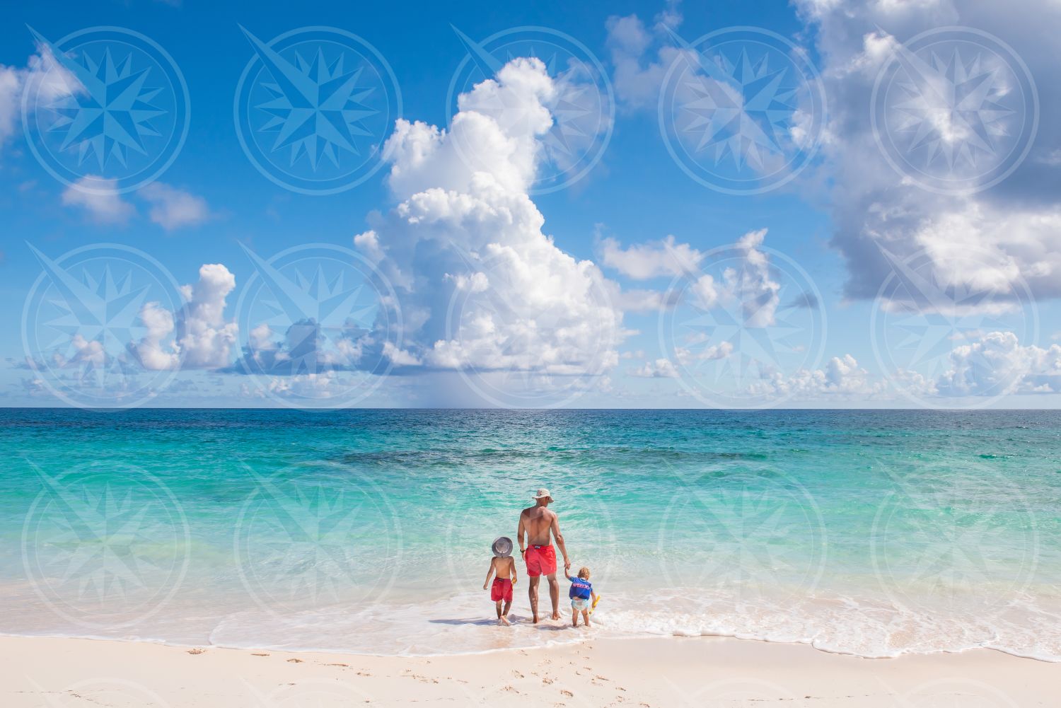 Man with two kids on white sand beach