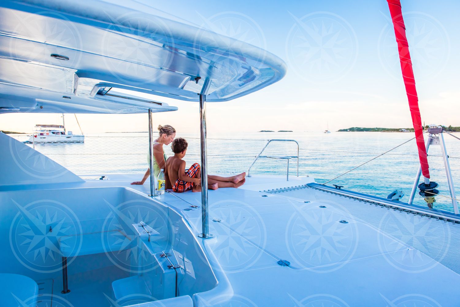 Woman and boy on sailboat in the morning