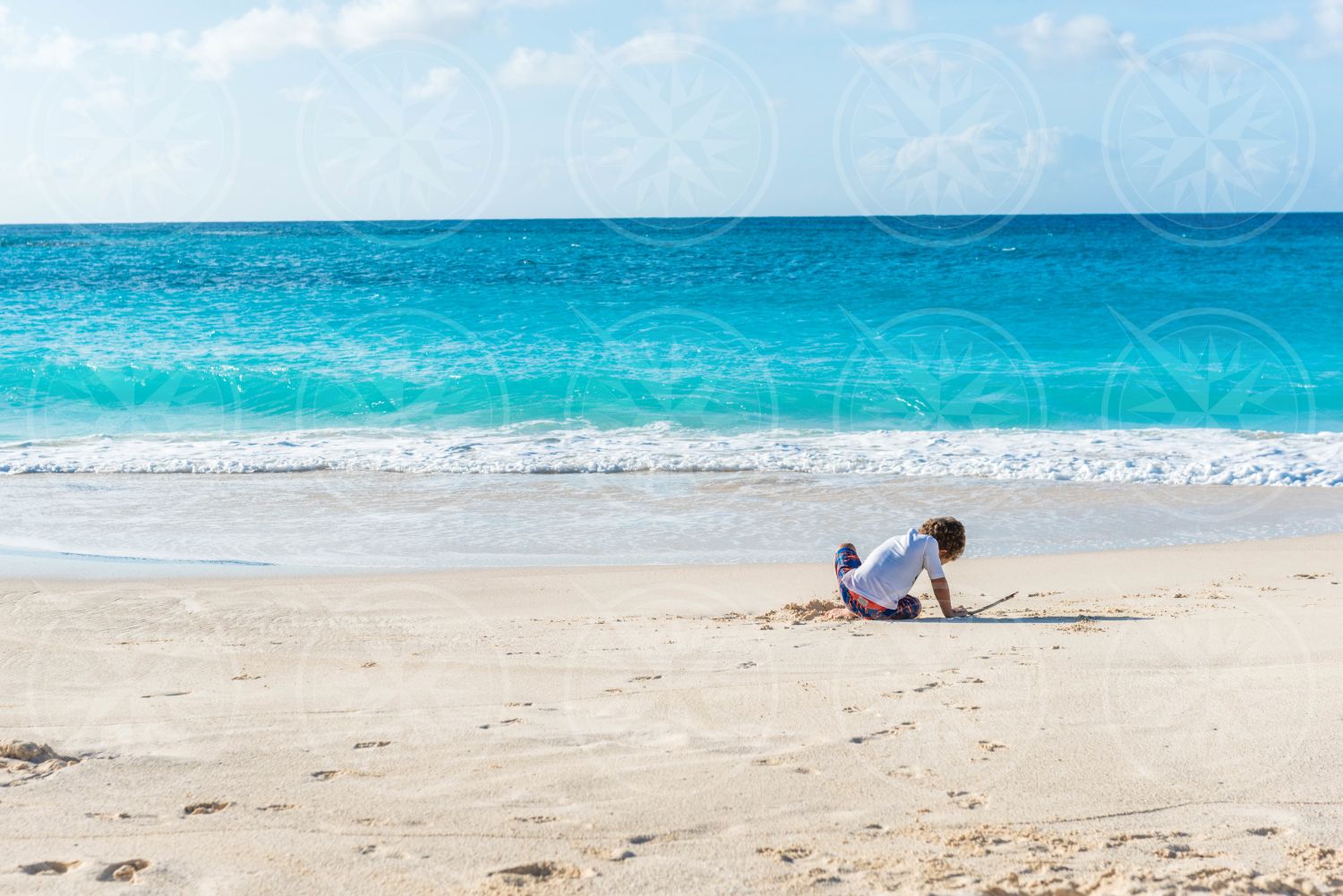 Young boy playing on white sand beach