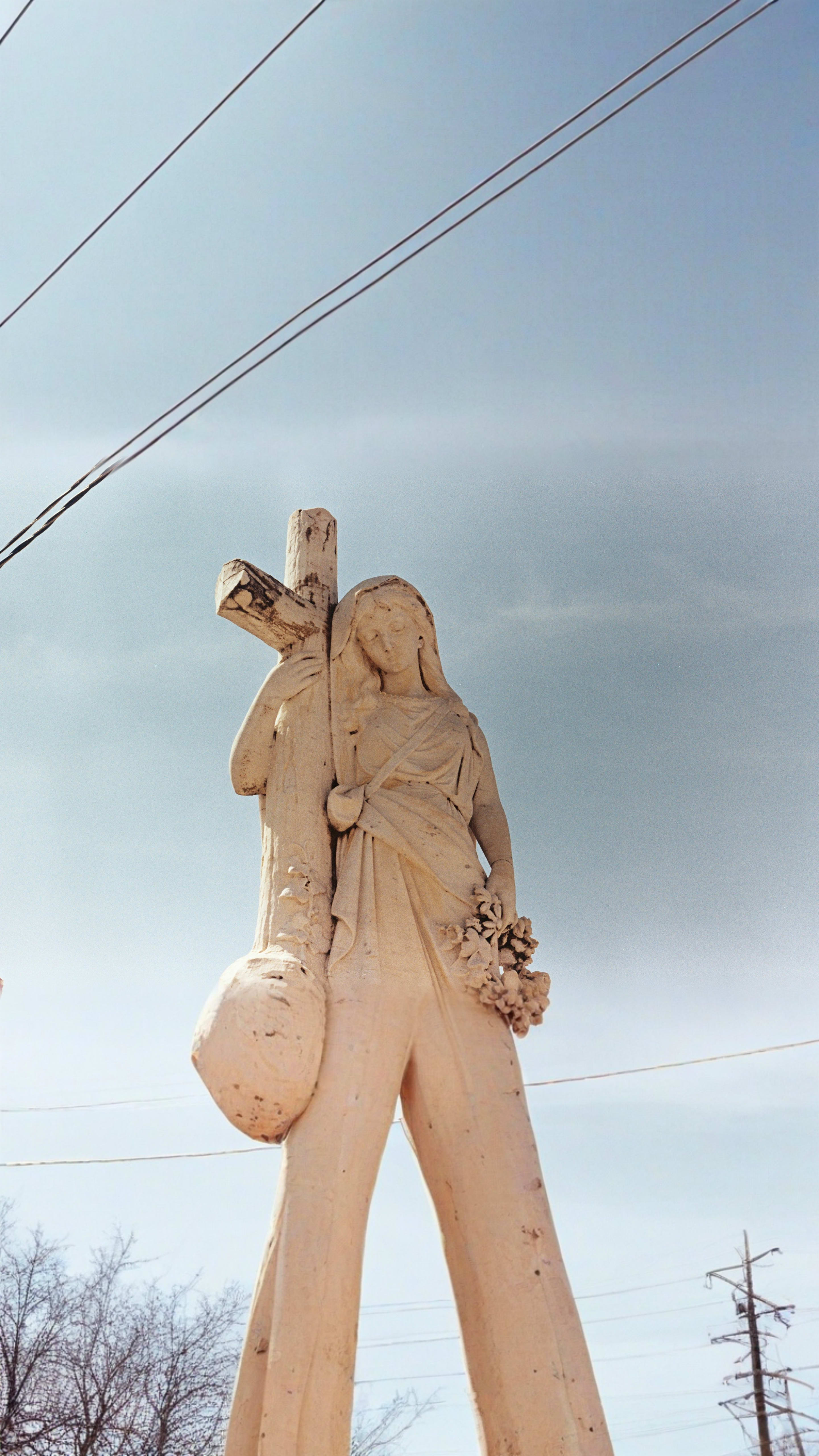 A marble statue of a woman and cross.