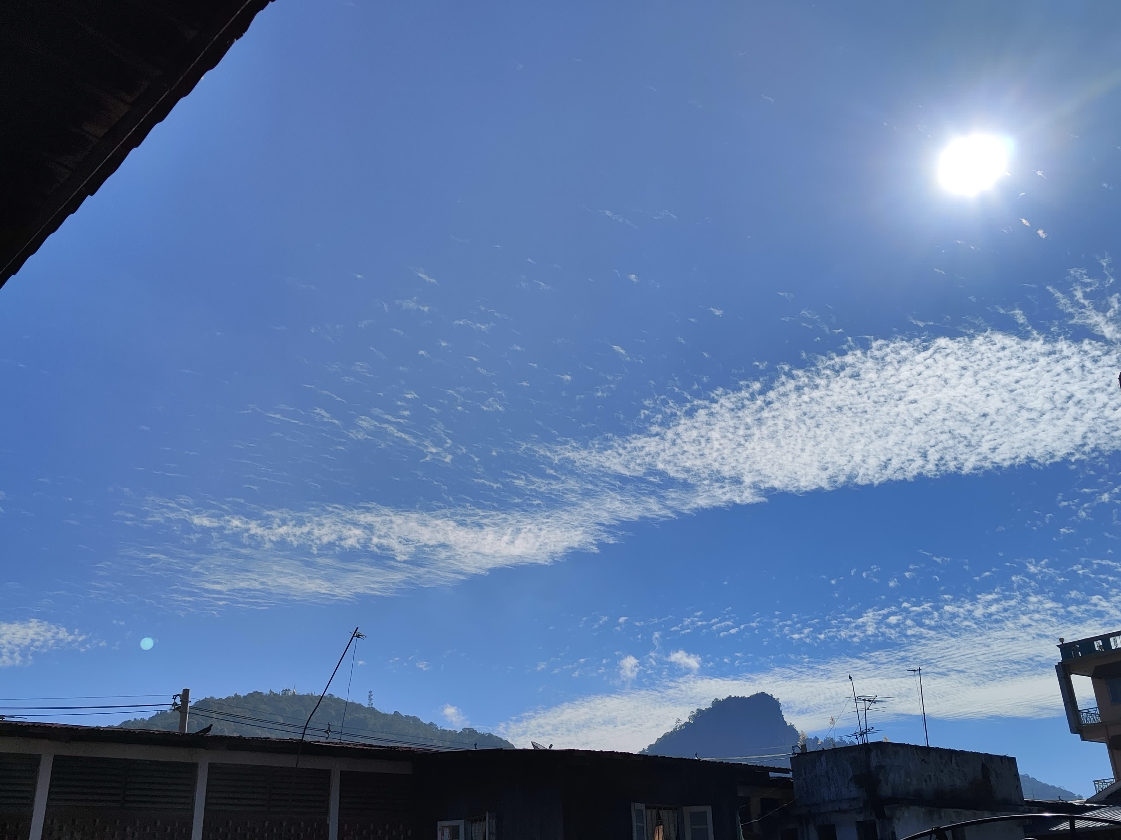 Wispy cirrocumulus clouds across deep blue sky