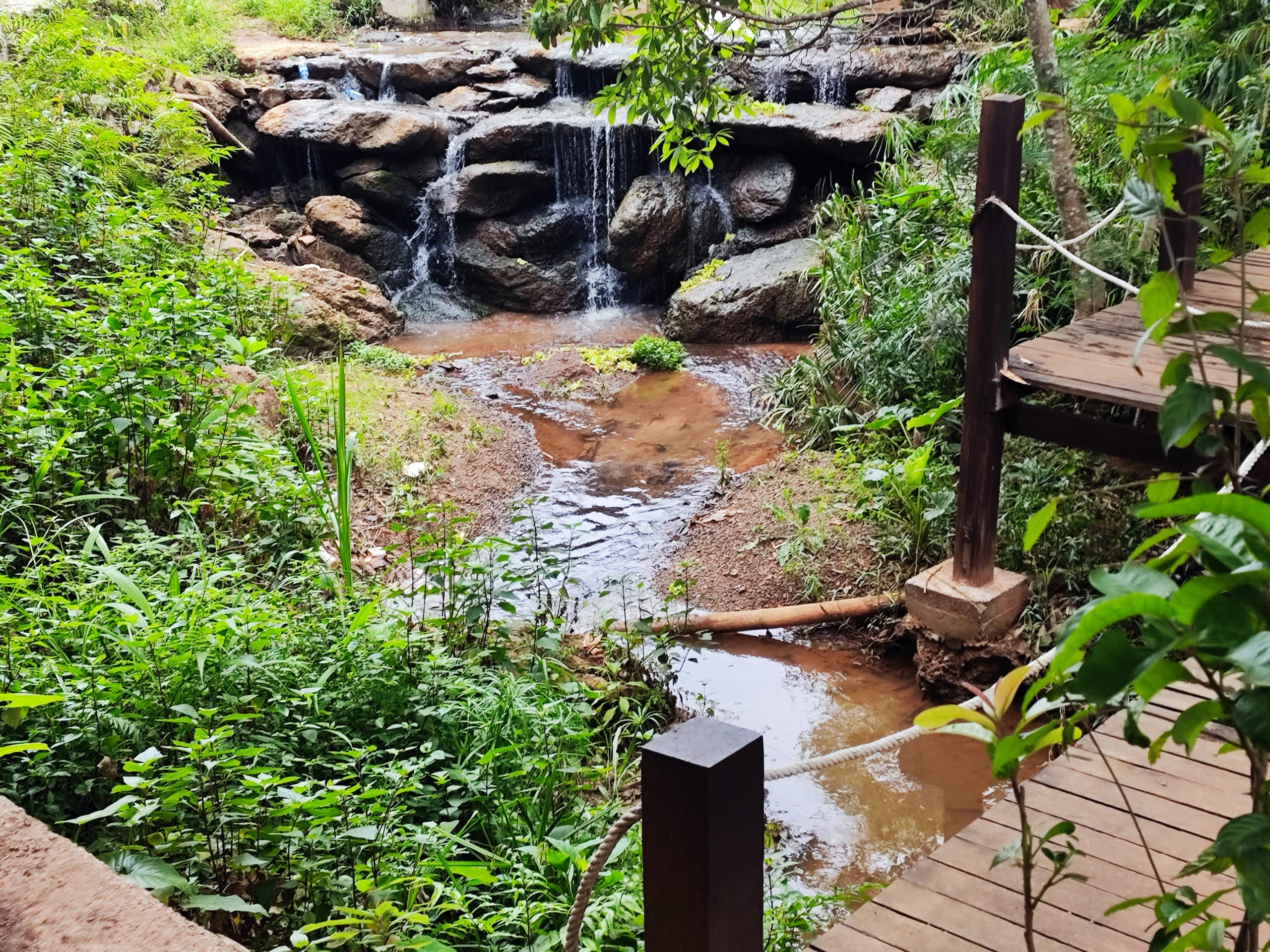 Tiered rock waterfall by the wooden path