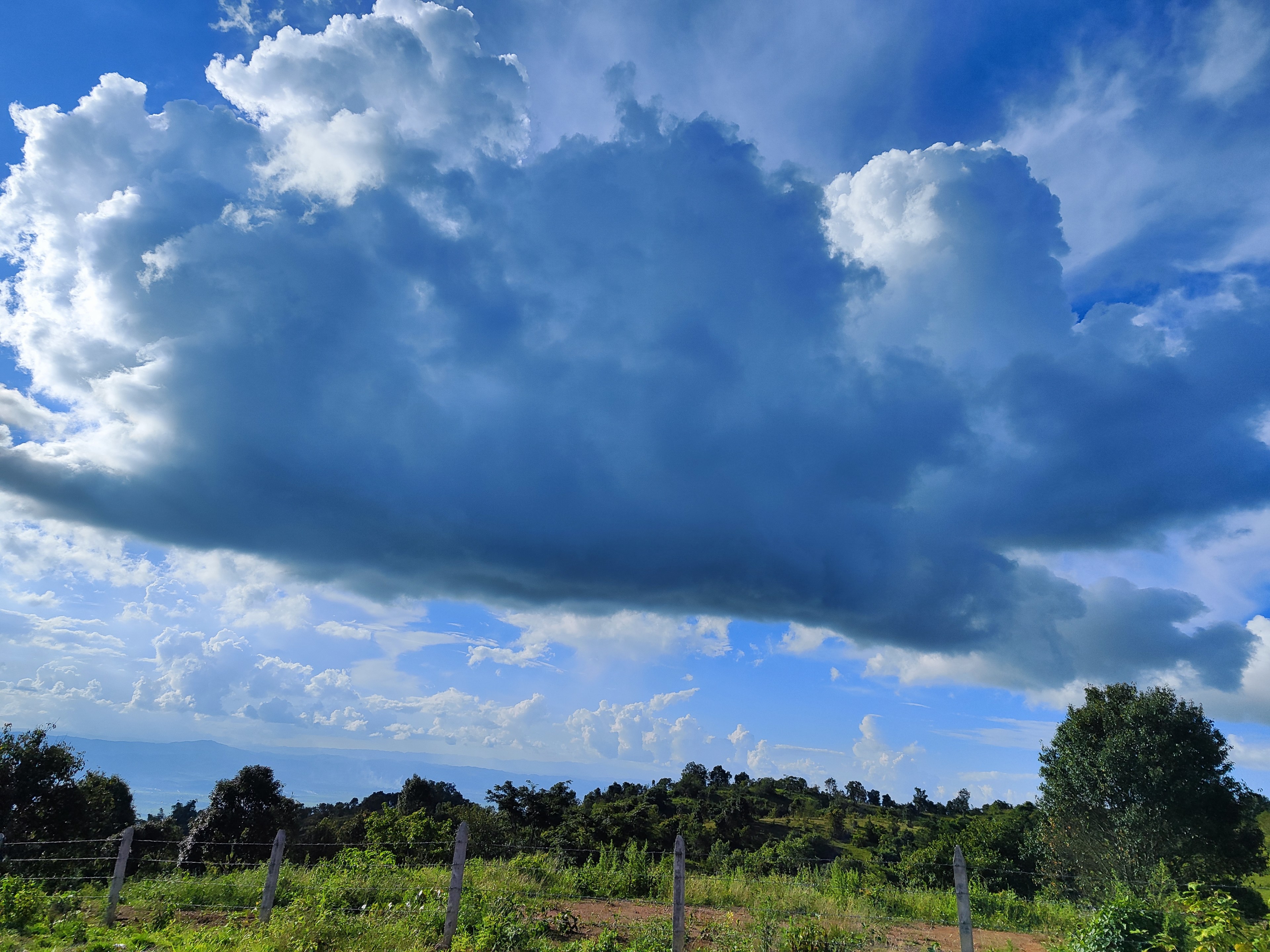 Huge storm cloud above the green hills