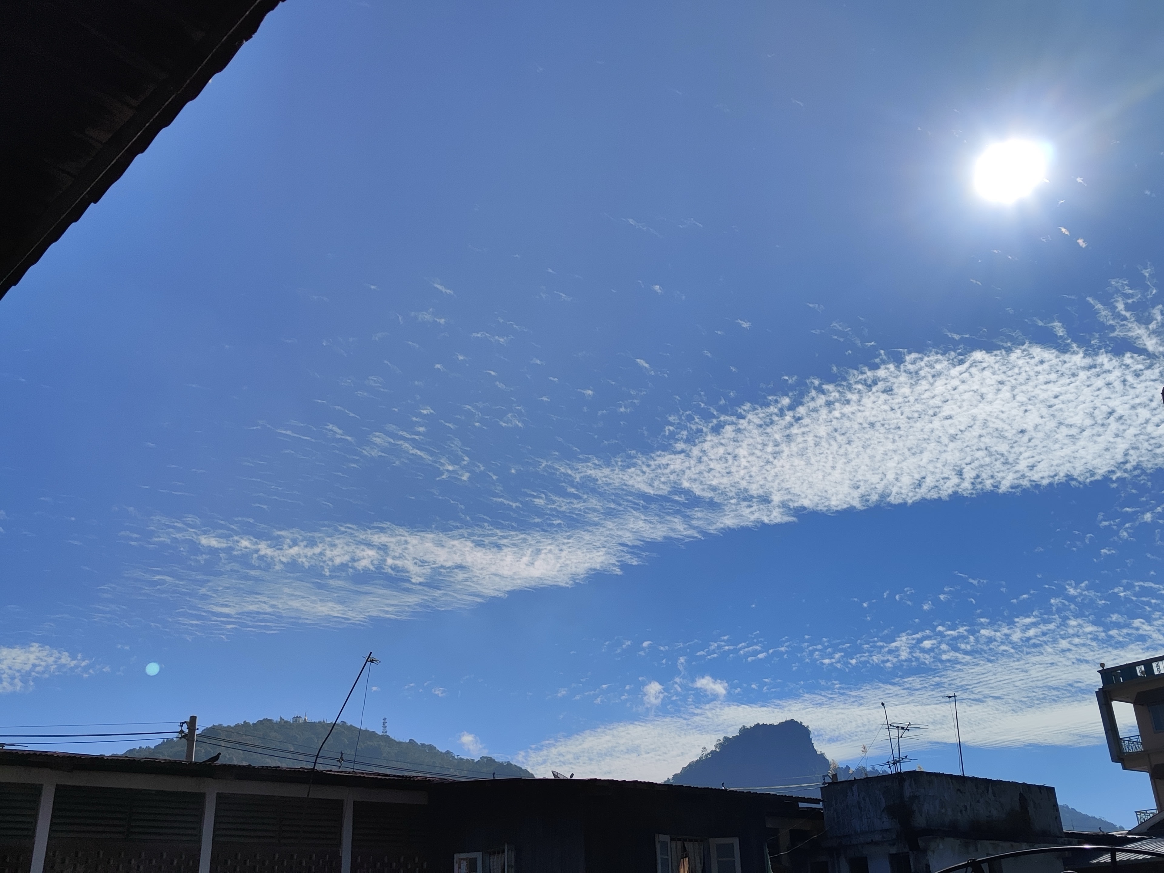 Wispy cirrocumulus clouds across deep blue sky