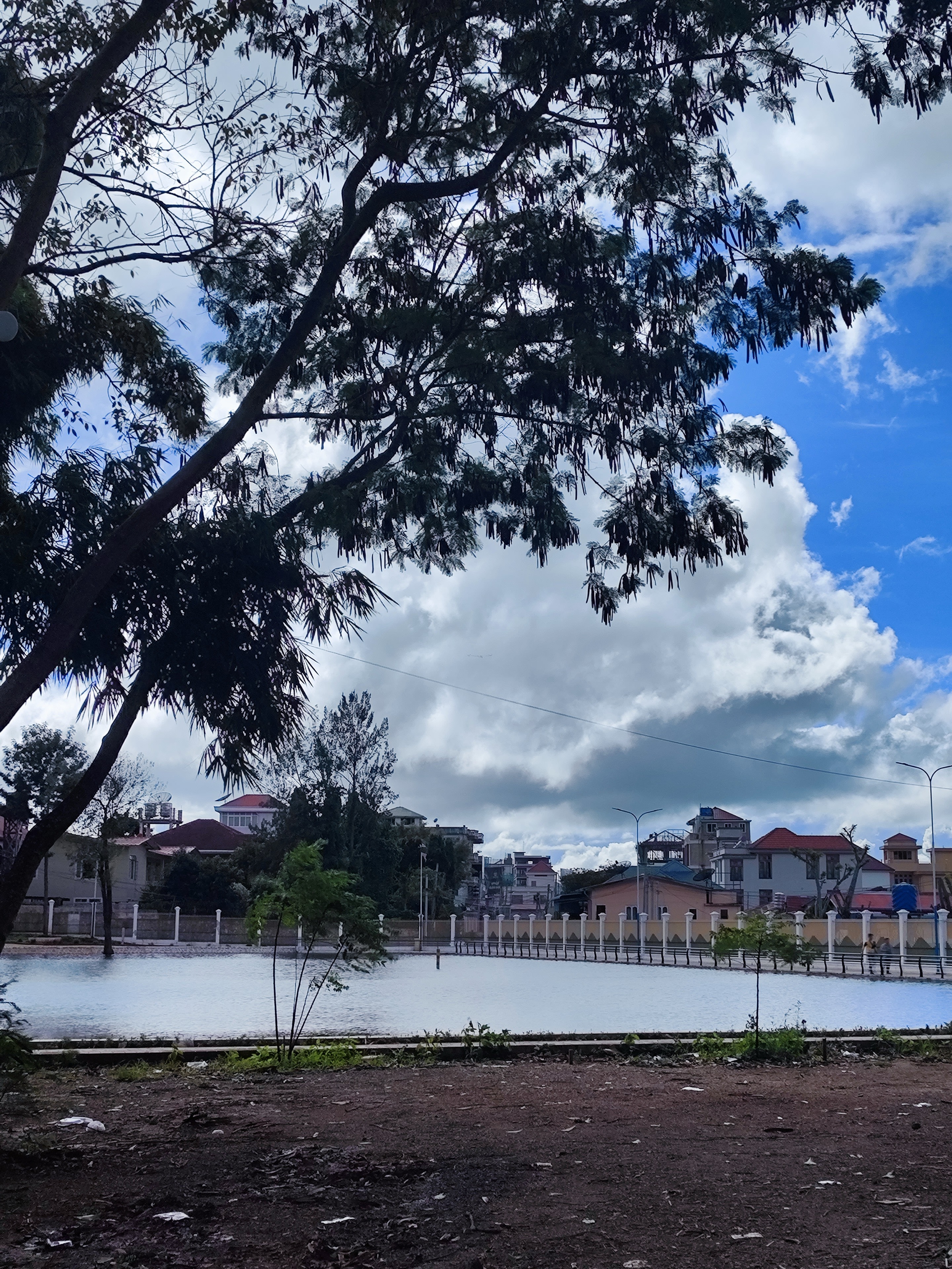 Calm town lake under fluffy clouds