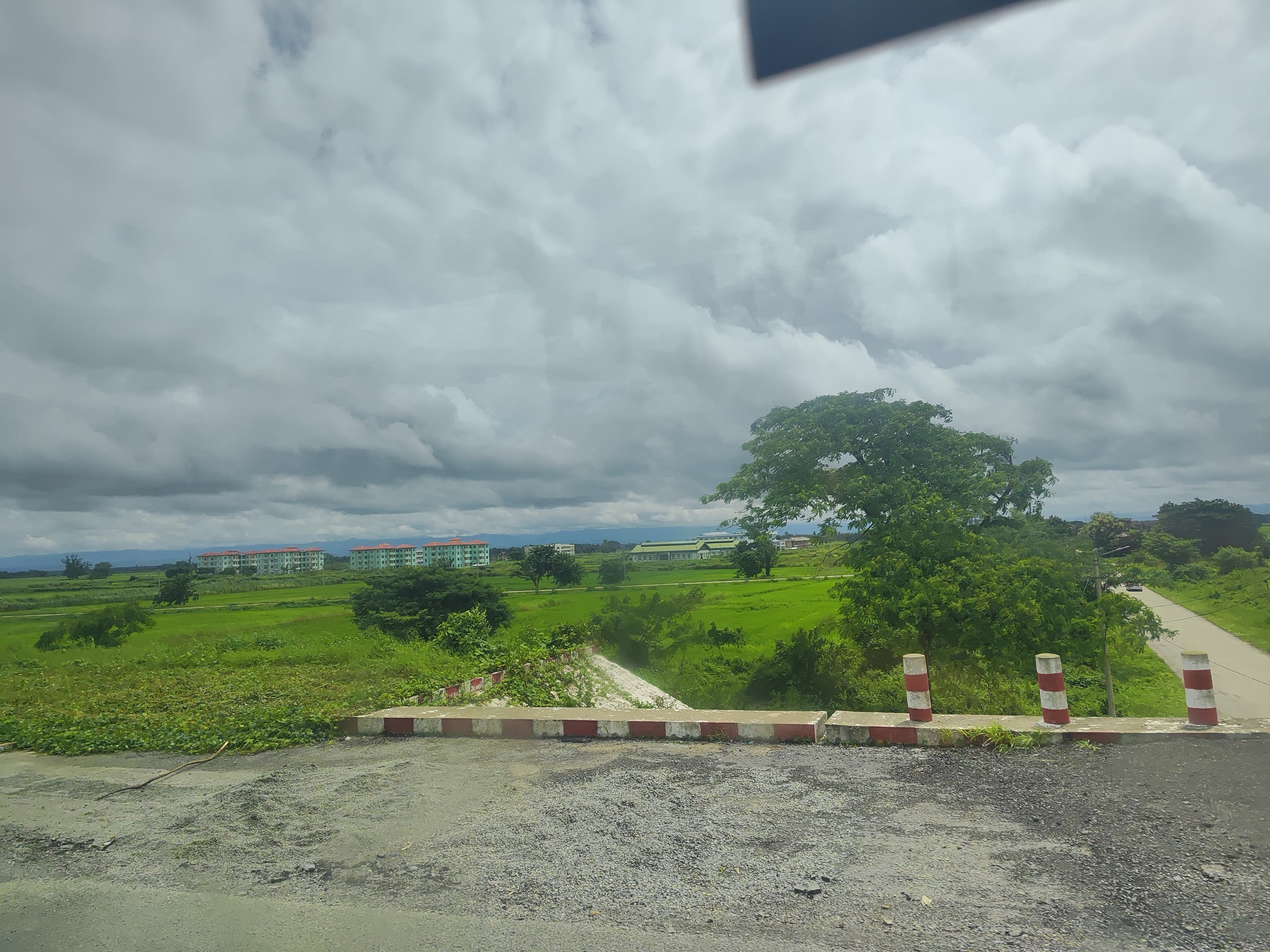 Green paddy fields under dark monsoon clouds