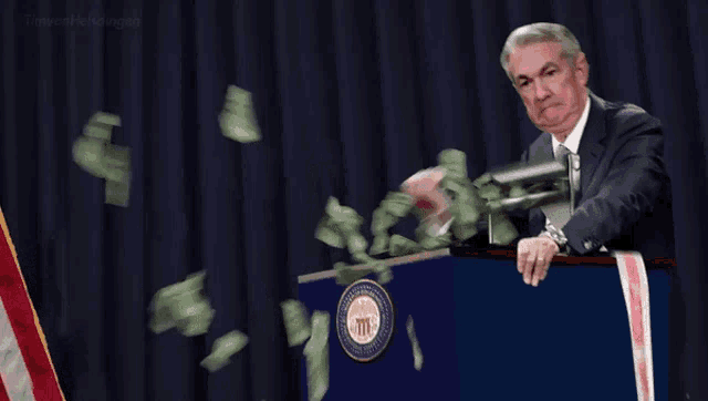 Animated GIF of Jerome Powell, chair of the Federal Reserve, operating a money printing machine