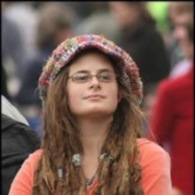 College Liberal meme template: A person wearing glasses and a knitted hat, with dreadlocks. They have a neutral expression.