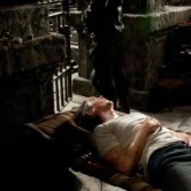 BANE AND BRUCE meme template: A muscular figure (Bane) stands over a defeated and prone figure (Bruce Wayne) in a dark, dungeon-like environment.