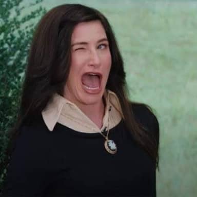 Agnes Harkness Winking meme template: A woman winks and screams with her mouth wide open, her face contorted in an exaggerated expression.